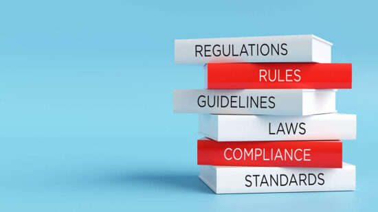 Stack of books representing regulatory compliance and legal standards