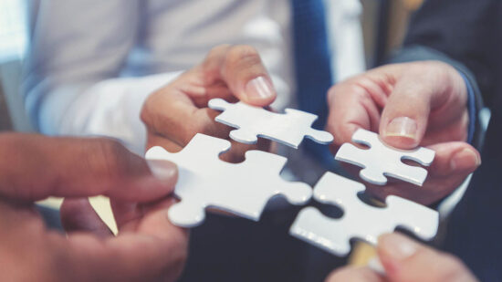 Group of business people holding a jigsaw puzzle pieces.