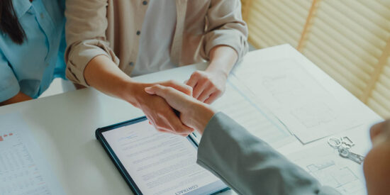 Close-up of Asian tenants sign house agreements on tablet and give them to female real estate agent after showing new houses. Landlord selling real estate to customers for investment.