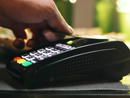 Credit card machine for money transaction. Close up of male hold in hand wireless modern bank payment terminal to process acquire credit card payments black card. Credit card through pos terminal
