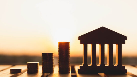 Bank symbol with with coins stack. Concepts of the banking system, rising interest rates, inflation, deflation, and savings.