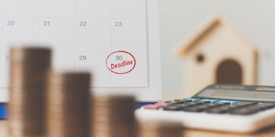 Tax payment season and finance debt collection deadline concept. Money coins stack, calendar, calculator and wooden house