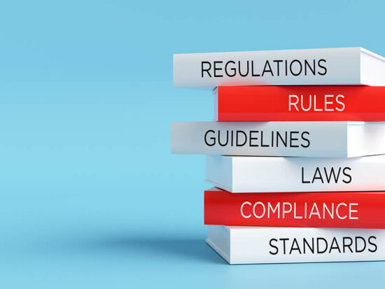 Stack of books representing regulatory compliance and legal standards