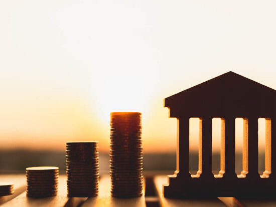 Bank symbol with with coins stack. Concepts of the banking system, rising interest rates, inflation, deflation, and savings.