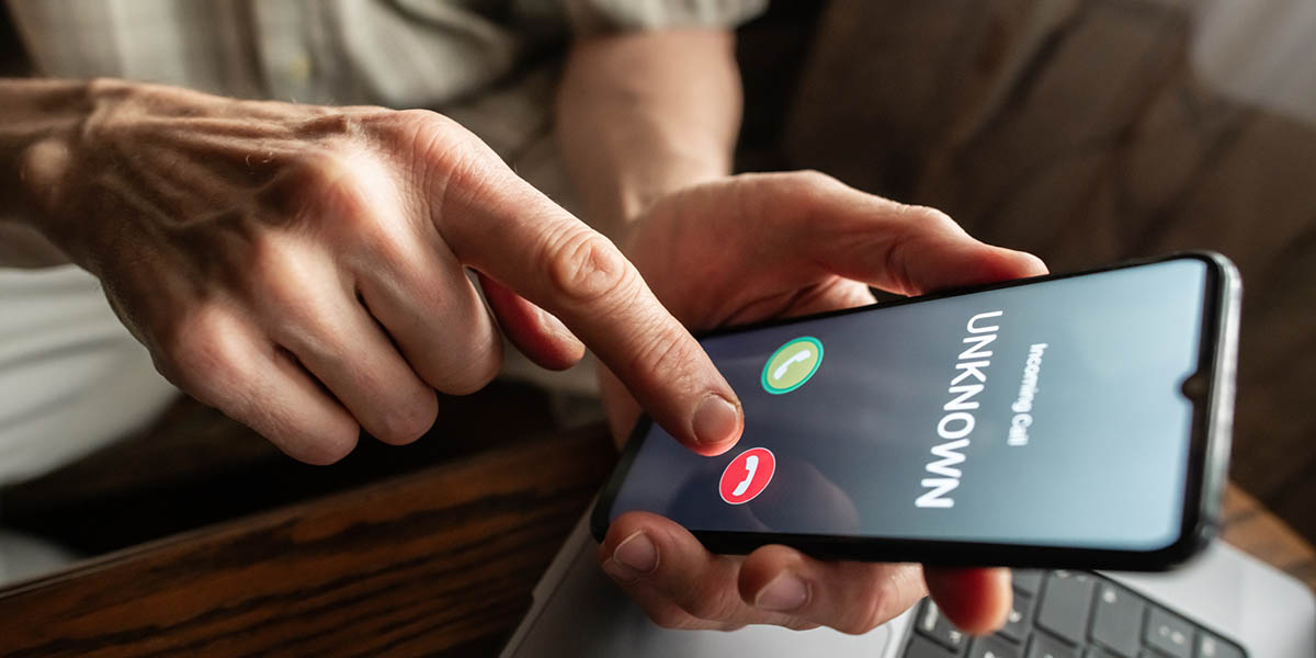 Senior man refuses to answer to a call from unknown number. Scam and fraud prevention with smartphone concept.